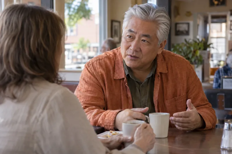 A visitor discussing a local errand over coffee in a modest neighborhood diner
